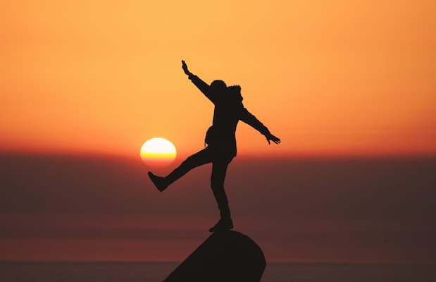 person trying to balance on a rock